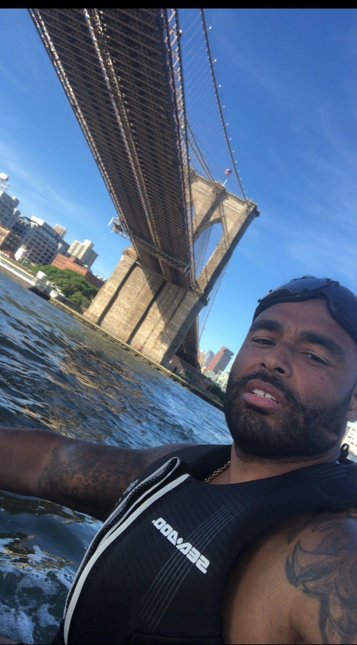 Frank Smith III wearing a flotation vest while jet skiing beneath the Brooklyn Bridge