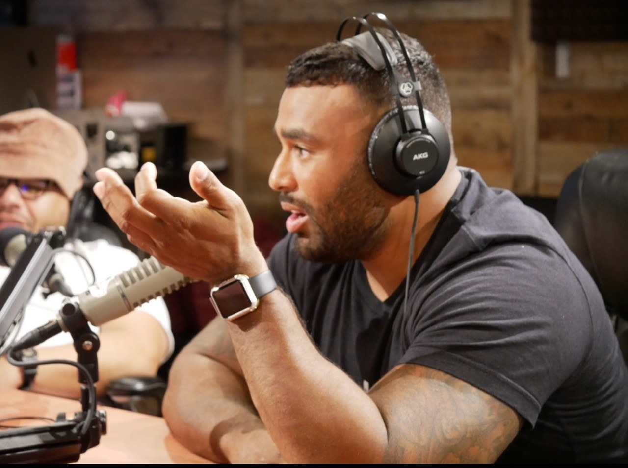 Frank Smith III speaking into a podcast microphone with headphones