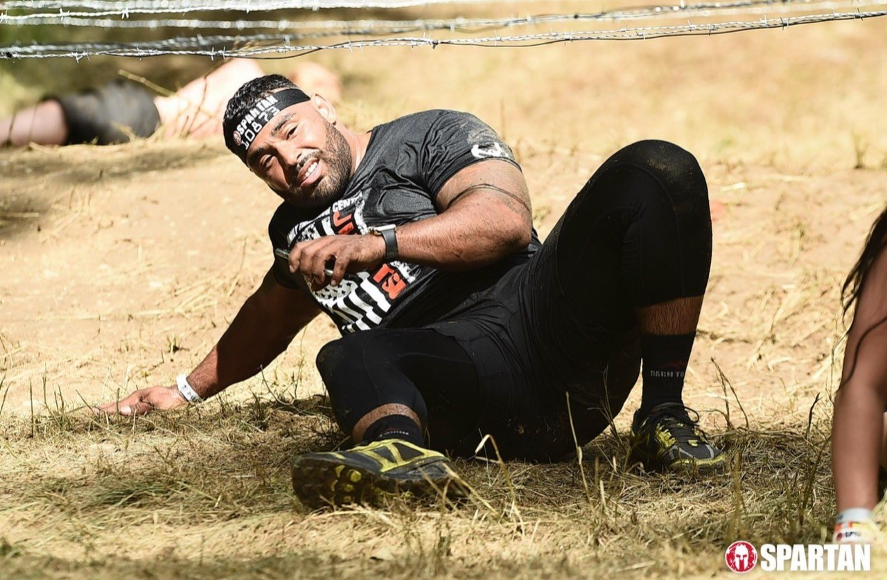 Frank Smith III moving beneath wire during a Spartan obstacle