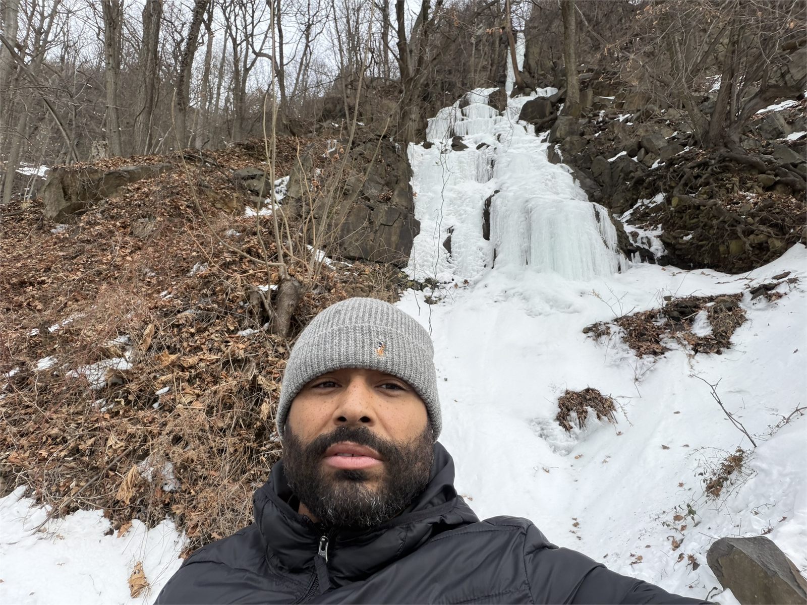 Frank Smith III winter hiking near an ice waterfall